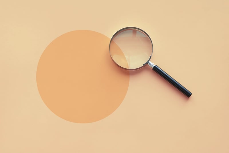 Magnifying glass on orange background