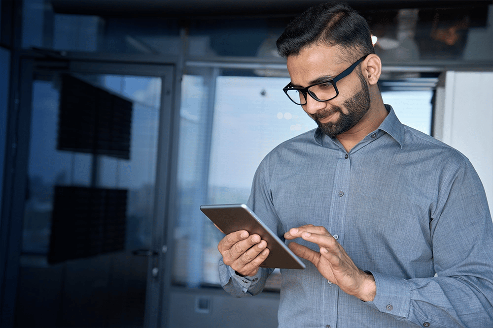 Homme en train d'utiliser sa tablette dans un bureau