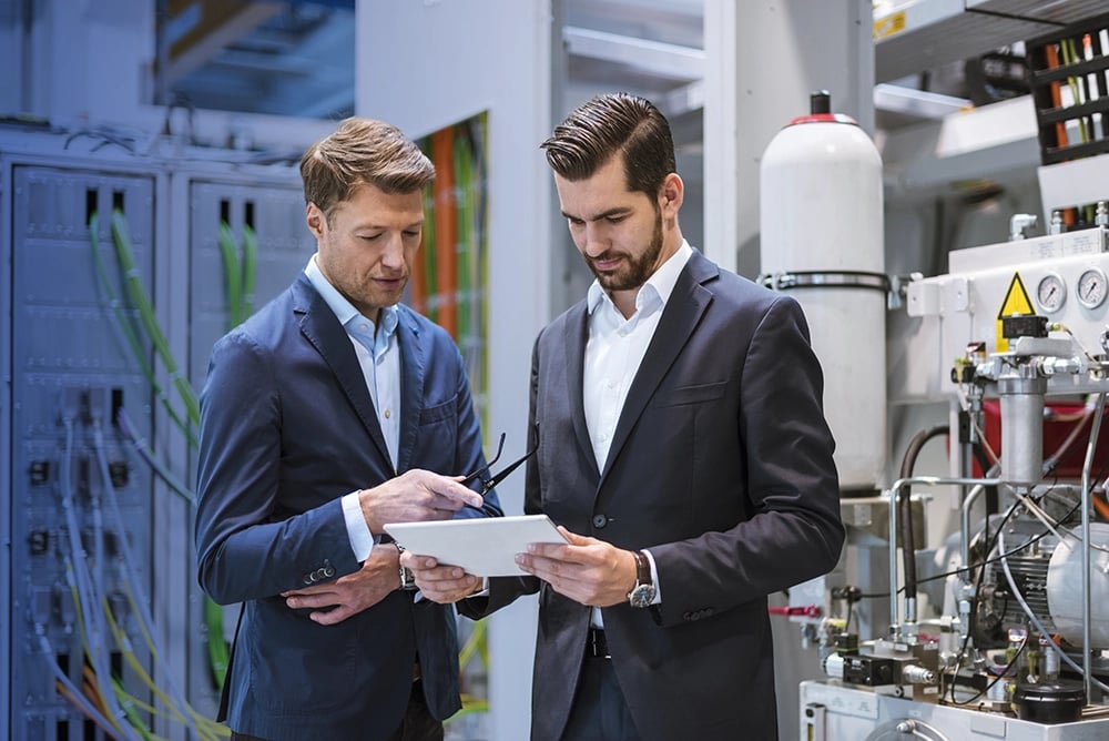 CFOs in warehouse working on tablet